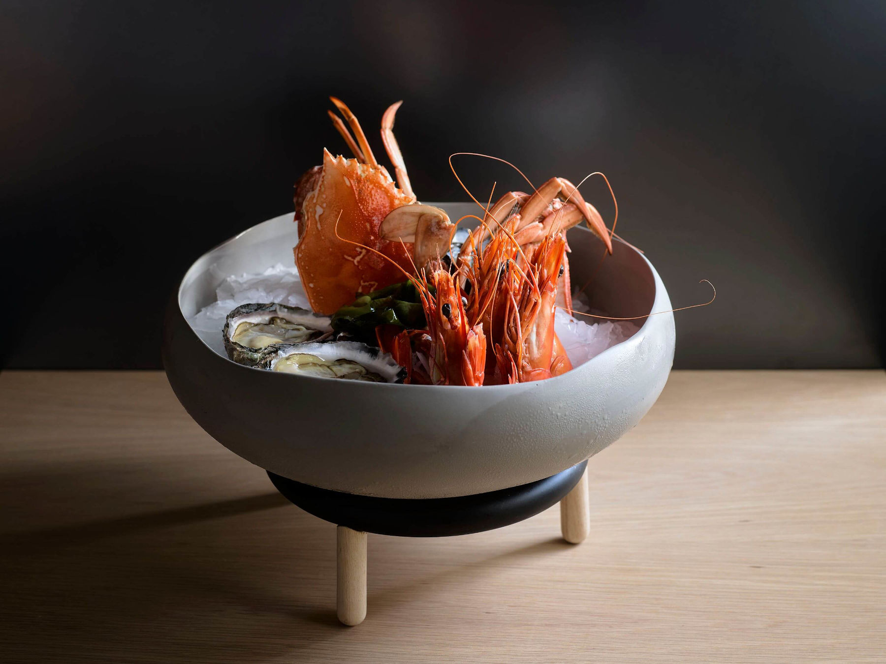 A prawns dish being served with oysters for a customer
